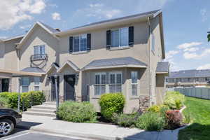 View of property featuring stucco siding and uncovered parking