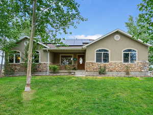 Single story home with stone siding, stucco siding, and solar panels