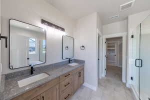 Bathroom featuring double vanity and a stall shower