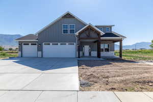 View of front facade with a mountain view, a porch, concrete driveway