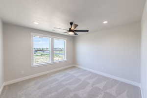 Empty room featuring ceiling fan, light carpet, recessed lighting, and a textured ceiling