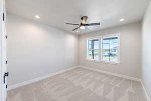 Spare room featuring ceiling fan, light carpet, and recessed lighting