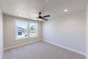Empty room featuring light carpet, ceiling fan, a textured ceiling, and recessed lighting