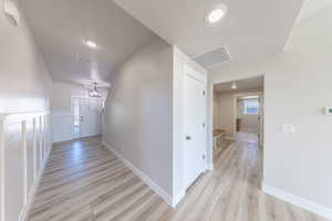 Corridor with light wood-style floors and recessed lighting