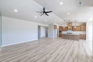 Unfurnished living room featuring a ceiling fan, recessed lighting, lofted ceiling, and light wood-style floors