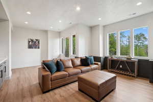 Living area with recessed lighting, healthy amount of natural light, and light wood-style floors