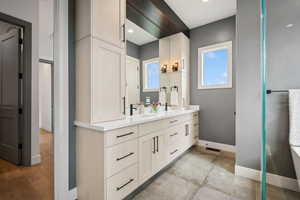 Bathroom with baseboards and double vanity