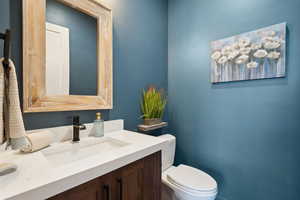 Half bath featuring toilet and vanity