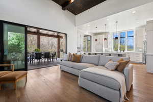 Living area with hardwood / wood-style flooring, high vaulted ceiling, recessed lighting, and a wood ceiling with exposed beams