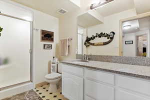 Full bath with vanity, a shower stall, and tile patterned flooring