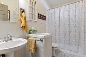 Bathroom with wainscoting and tile patterned floors