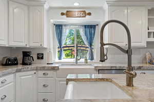 Kitchen featuring white cabinetry, tasteful backsplash, light countertops, and recessed lighting