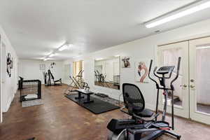 Exercise area featuring french doors and baseboards