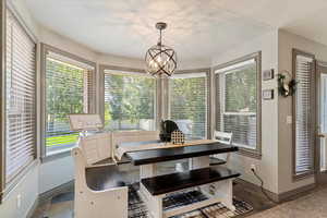 Dining room with healthy amount of natural light, a chandelier, and a textured ceiling