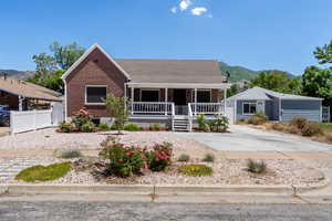 View of front of home with a porch, brick siding, and a mountain view