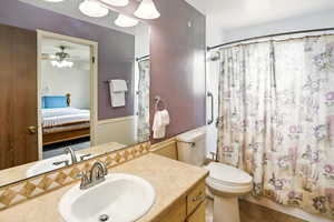 Bathroom featuring connected bathroom, vanity, tile patterned floors, ceiling fan, and a shower with curtain