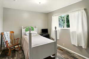 Bedroom with baseboards and dark wood-style flooring