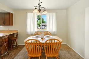 Dining space with a chandelier and carpet