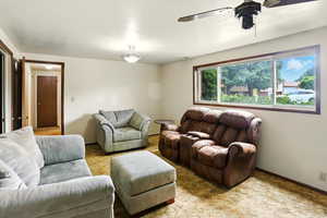 Living room featuring a ceiling fan and carpet flooring