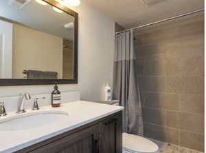 Bathroom with tiled shower and vanity