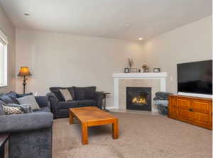 Carpeted living room with a tile fireplace