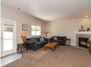 Living room featuring a glass covered fireplace and carpet flooring