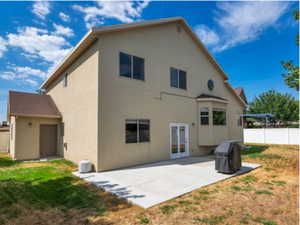Rear view of property with a patio, stucco siding, and french doors