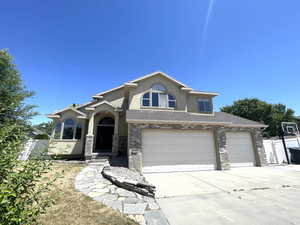 View of front of property featuring concrete driveway, stucco siding, and an attached garage