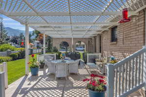View of patio featuring outdoor dining area, a pergola, and a mountain view. Built in bbq