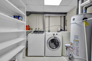 Washroom featuring double secured water heaters and washing machine and clothes dryer