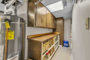 Basement with double water heaters, light floors, and baseboards