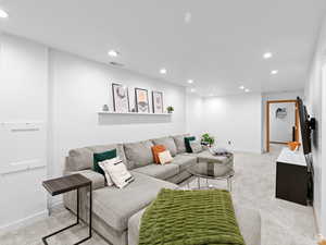 Living area with recessed lighting and light colored carpet