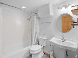 Full bathroom with shower / bathtub combination with curtain, a textured ceiling, tile patterned floors, and recessed lighting