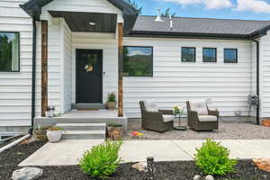 Doorway to property featuring a shingled roof