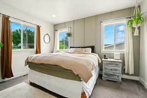 Carpeted bedroom featuring multiple windows and recessed lighting