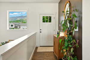 Entrance foyer with dark wood-type flooring, healthy amount of natural light, and a mountain view