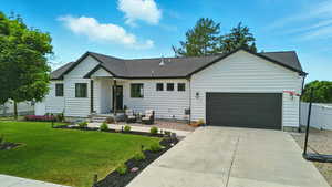 View of front facade featuring a garage, driveway, and roof with shingles