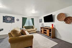 Living area featuring dark carpet and baseboards