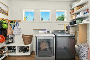 Washroom with independent washer and dryer and wood finished floors