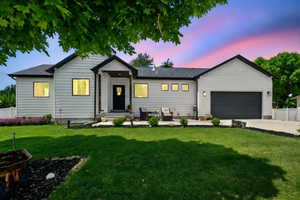 View of front facade with a garage, driveway, and a shingled roof