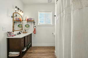 Full bath featuring vanity and wood finished floors