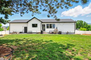 Back of property with a fenced backyard and a patio