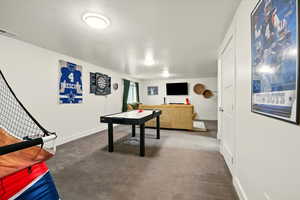 Game room featuring carpet and baseboards