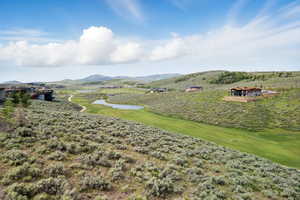 View of mountain backdrop with a large body of water and a golf course