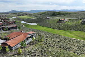 View of mountain background featuring a large body of water and a local golf course