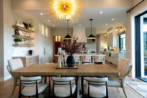 Dining room featuring light wood finished floors, recessed lighting, and a chandelier