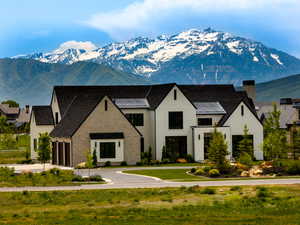 View of front of property with a mountain view, a chimney, a standing seam roof, and a metal roof