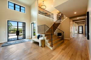 Foyer with stairs, a chandelier, parquet flooring, recessed lighting, and a high ceiling