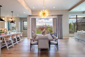 Dining area with light wood-style floors, a chandelier, and recessed lighting