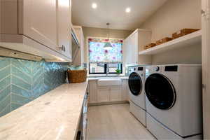 Laundry area with washing machine and clothes dryer, recessed lighting, and cabinet space
